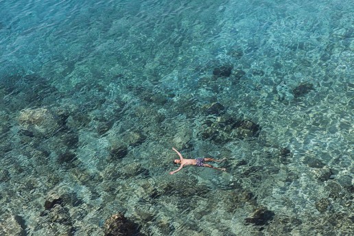 Man floating in turquiose sea in Greece
